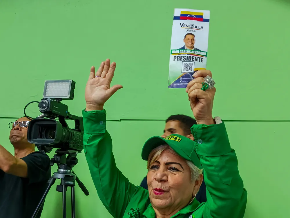 Militante de COPEI sostiene un volante del candidato presidencial Juan Carlos Alvarado