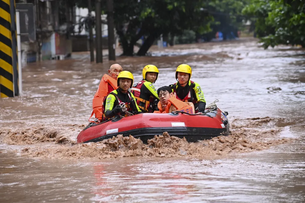 Rescatistas trasladan a residentes atrapados por inundaciones, en el distrito de Wanzhou, en la municipalidad de Chongqing, en el suroeste de China / Foto: Xinhua Ran Mengjun