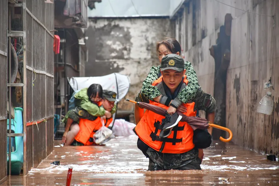 Agentes de la Fuerza de Policía Armada China transfieren a residentes atrapados por las inundaciones en el distrito de Wanzhou / Foto: Xinhua - Li Yuyang)