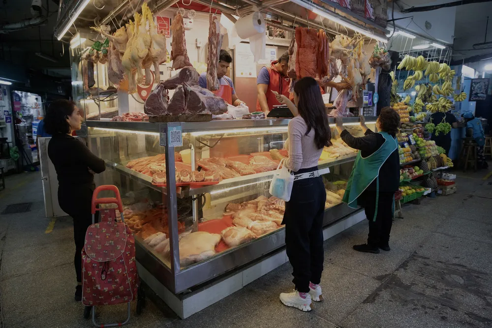Mujeres compran carne en un mercado, en el distrito de Surquillo, en Lima, Perú, el 15 de agosto de 2023. (Xinhua/Mariana Bazo)