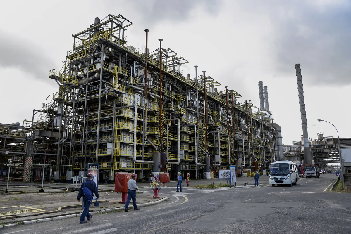 Los trabajadores caminan junto a un área de producción de nafta en una planta petroquímica en Camacari, Brasil.