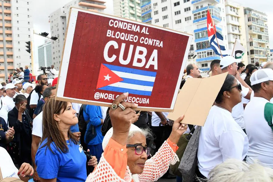 Una mujer sosteniendo un cartel durante una marcha para exigir el fin del bloqueo contra Cuba. Xinhua/Joaquín Hernández